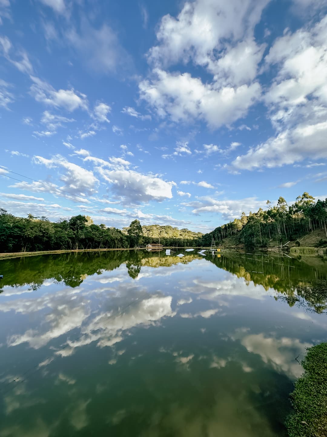 Impressionante vista frontal do Zuno Cable Park refletindo o céu azul de Curitiba